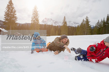 Young man and sons having snowball fight in winter, Elmau, Bavaria, Germany