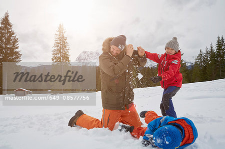 Man and sons having snowball fight in winter, Elmau, Bavaria, Germany