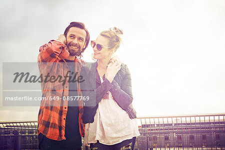 Cool mid adult couple on rooftop parking lot