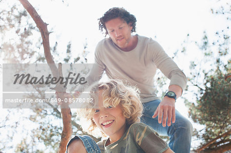 Father and son climbing tree