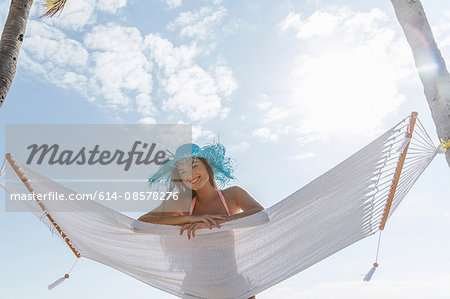 Portrait of young woman lying on hammock at Miami beach, Florida, USA