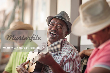 Man playing ukulele, entertaining friends