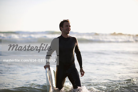 Male surfer standing in sea on Venice Beach, California, USA
