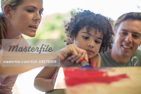 Family doing crafts together, painting wood