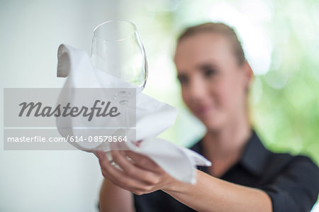 Waitress wiping wine glass