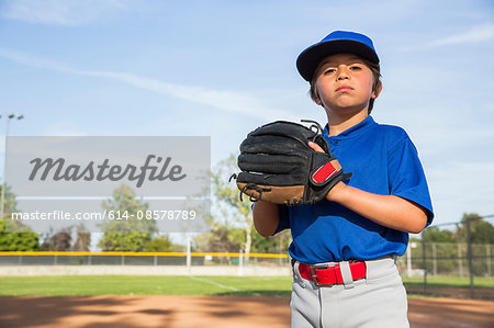 Portrait of confident boy wearing baseball glove at baseball practise