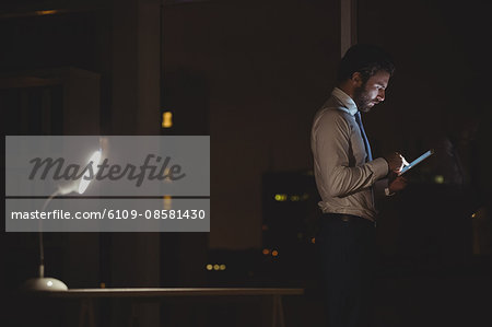 Businessman using tablet at night