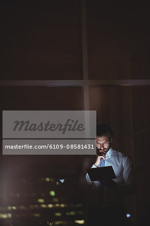 Businessman using tablet at night