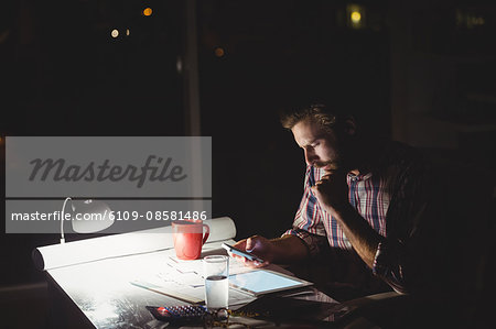 Hipster using a smartphone in darkness