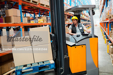 Warehouse worker driving forklift