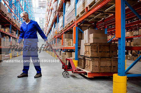 Man worker pulling the pallet truck