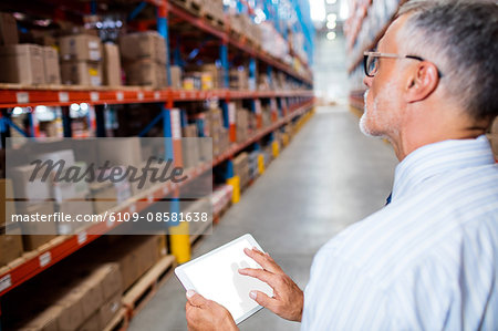 Focus on foreground of warehouse manager taking notes