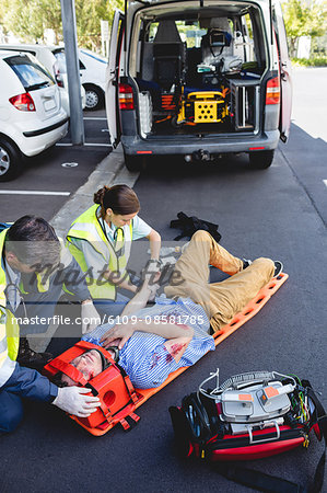 Ambulancemen healing injured man