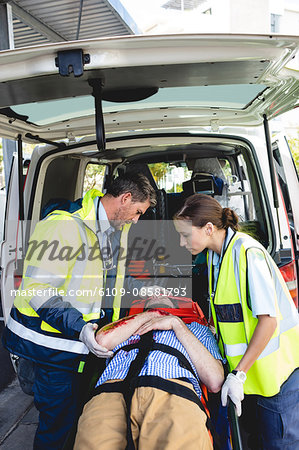 Ambulancemen carrying injured man on a stretcher