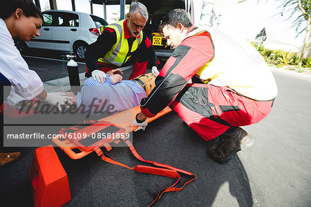 Injured man being healed by a team of ambulancemen