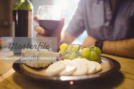 Close up view of red wine glass and cheeses