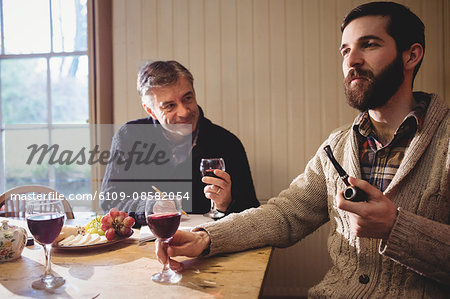 Mature and hipster man tasting red wine