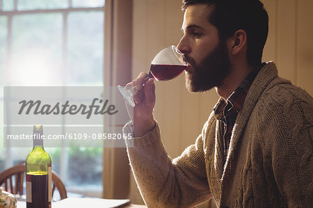 Profile view of hipster man drinking glass of wine