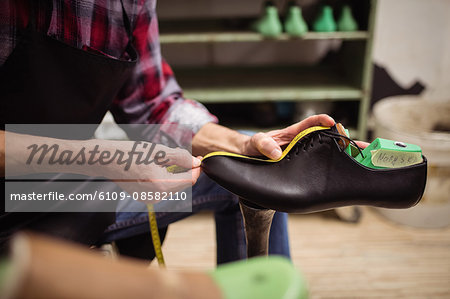 Close up of cobbler measuring a shoe