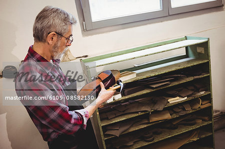 Profile view of cobbler making a shoe