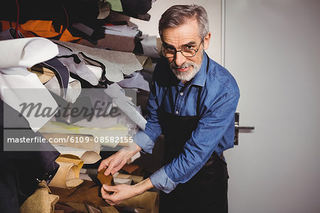 Cobbler posing with a piece of leather