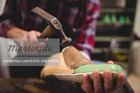 Close up of hand hammering on a shoe