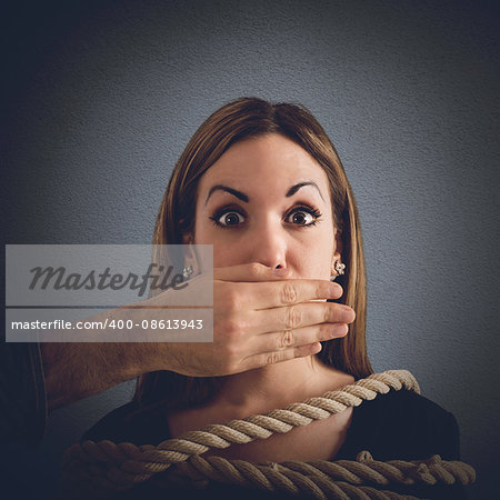Man covering mouth to a woman tied