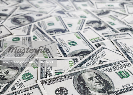 Pile of one hundred dollar bills. Money as background. Shallow depth of field. Selective focus.