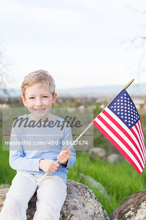 positive smiling boy holding american flag and celebrating 4th of july