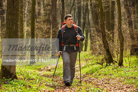 Hiker - man hiking in forest. Male hiker looking to the side walking in forest. Caucasian male model outdoors in nature.