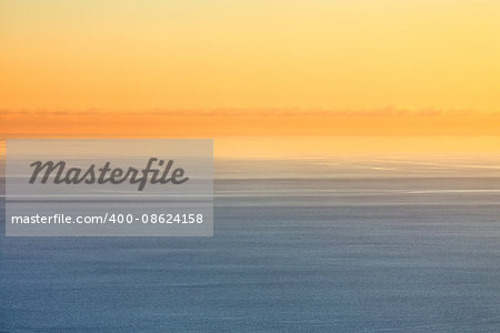 Orange sunset over the blue sea in pastel colors
