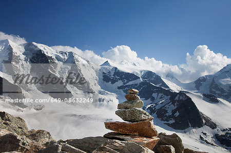 Rocks stacked by snowy rural mountains