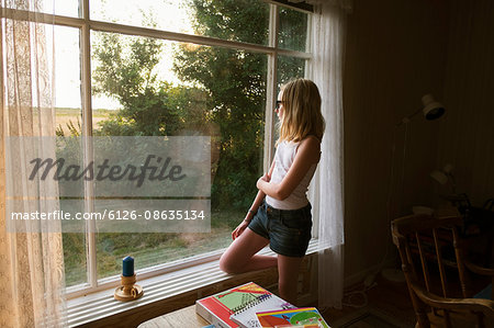 Sweden, Skane, Vejbystrand, Girl (10-11) looking though window