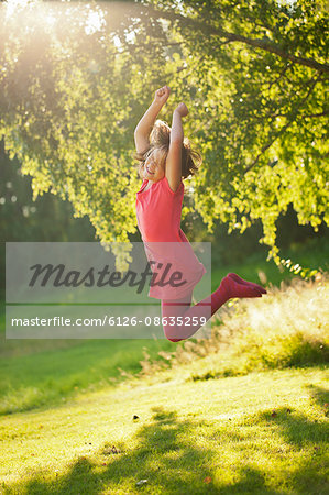 Sweden, Smaland, Girl (10-11) jumping in park