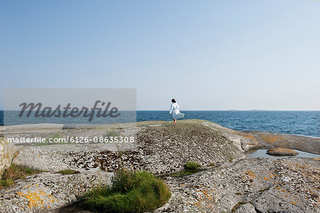 Sweden, Stockholms Archipelago, Sodermanland, Haninge, Norsten, Girl (12-13) on rock looking at sea