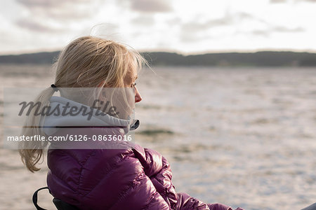 Sweden, Bohuslan, Halleback, Portrait of blonde mature woman sitting at seaside