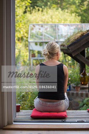 Sweden, Narke, Garphyttan, Woman sitting outdoors