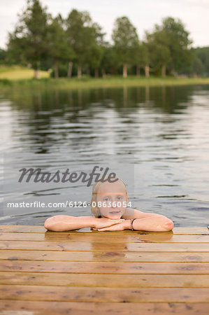 Sweden, Smaland, Braarpasjon, Portrait of girl (10-11) in lake with hands on chin