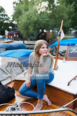 Sweden, Stockholm, Sodermalm, Portrait of woman sitting on boat