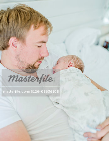 Sweden, Mid-adult man holding baby boy (0-1 months) in his arms