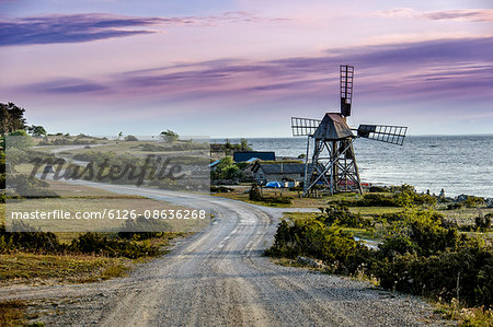 Sweden, Oland, Windmill between sea and winding road