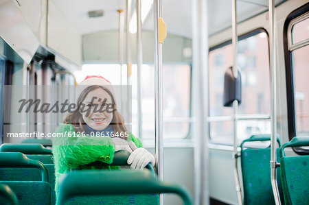 Finland, Helsinki, Young woman sitting in tram, leaning on grab rail