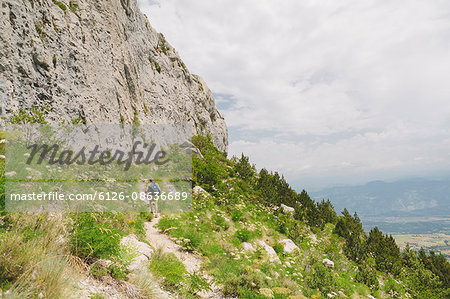France, Pelleautier, Ceuse, Young man hiking along mountain footpath