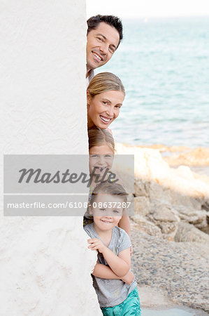 Family portrait, parents with their children stacked behind a wall