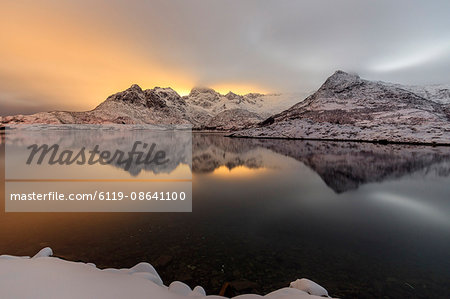 The light of the moon and snowy peaks reflected in the cold sea lit the night at Svolvaer, Lofoten Islands, Arctic, Norway, Scandinavia, Europe