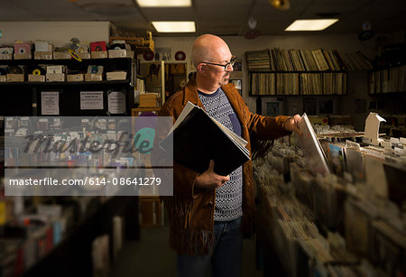 Mature man in record shop, filing records