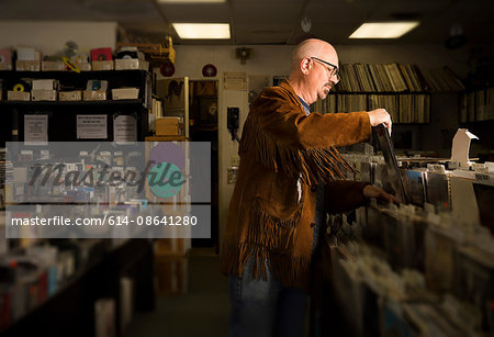 Mature man in record shop, filing records