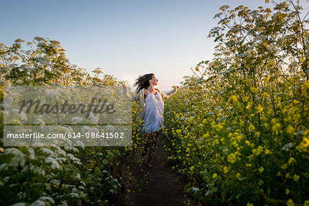 Woman walking through field of wildflowers