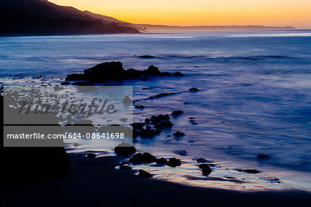 Elevated view of silhouetted beach at sunset, Los Angeles, California, USA
