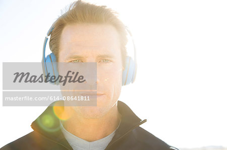 Sunlit portrait of man training, listening to headphones, El Mirage, California, USA